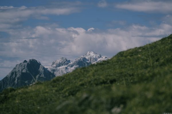 Berghang vor Gipfeln Alpin Team Trail 2026 Grüner Berghang vor schneebedeckten Gipfeln beim Alpin Team Trail 2026 in Werfenweng